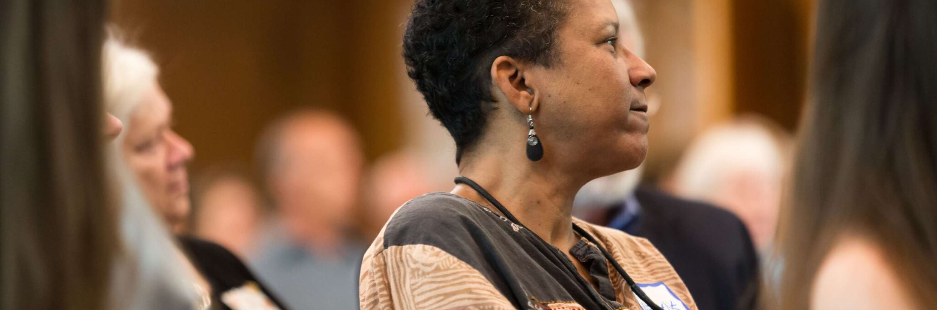 Rev. Archene Turner during worship sitting down and listening with slight smile